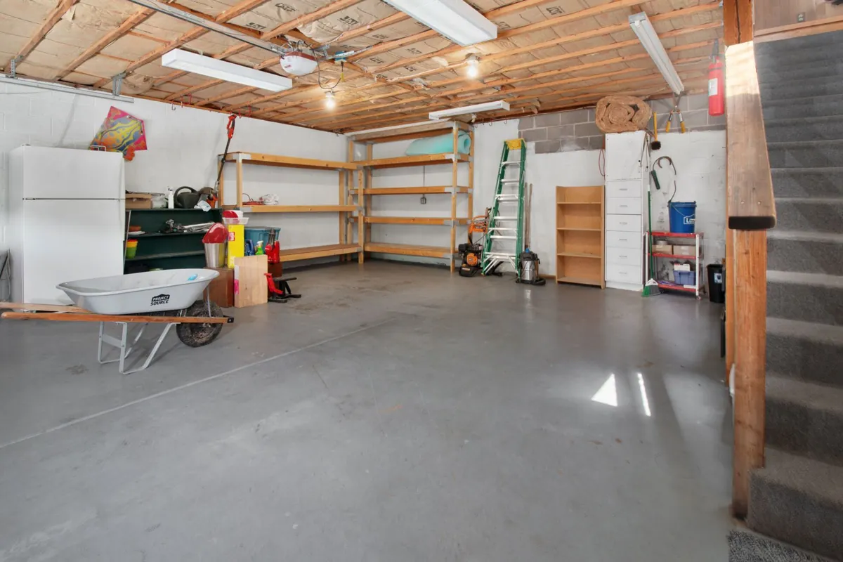 Garage interior with storage shelves and a bare concrete floor